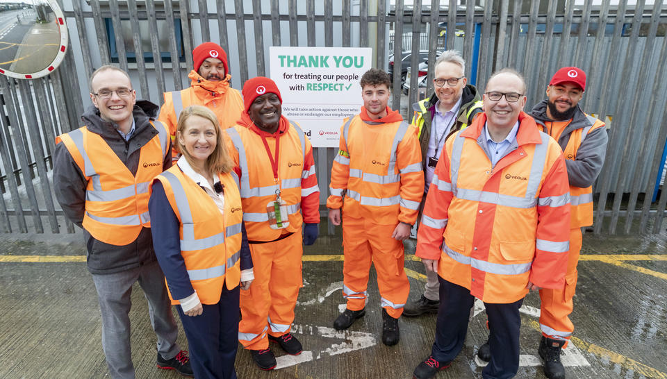 Veolia operatives, Sussex Police and Crime Commissioner and Council members stand smiling at the camera in front of a sign that says 'Thank you for treating our people with respect'.