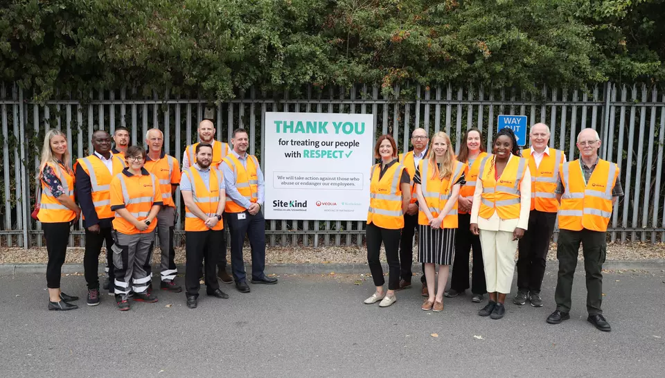 Veolia frontline operatives and senior management stand beside the SiteKind sign.