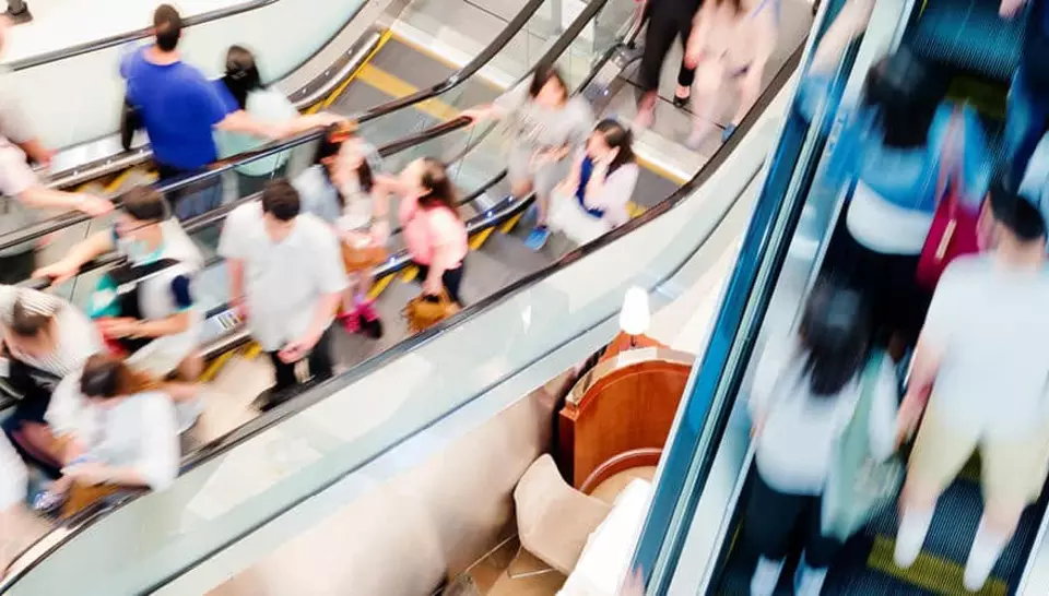 blurred image of lots of people on escalotors  