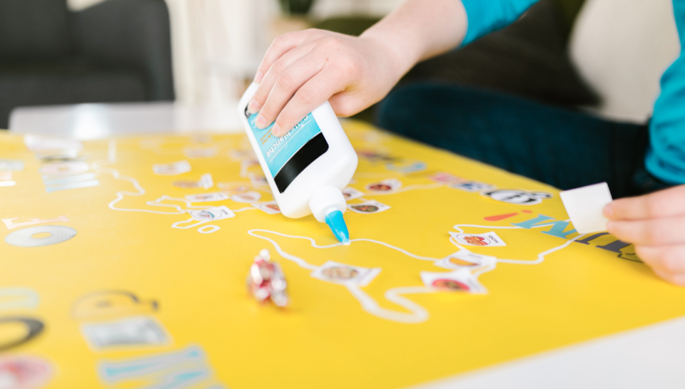 A person using glue to stick down artwork