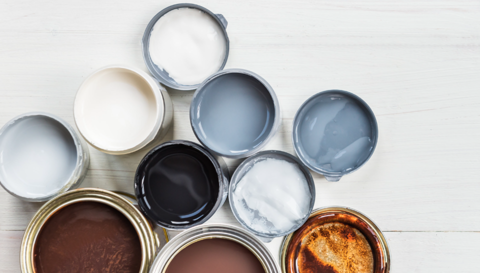 Open cans of paints and varnishes in different colours of white, brown and grey
