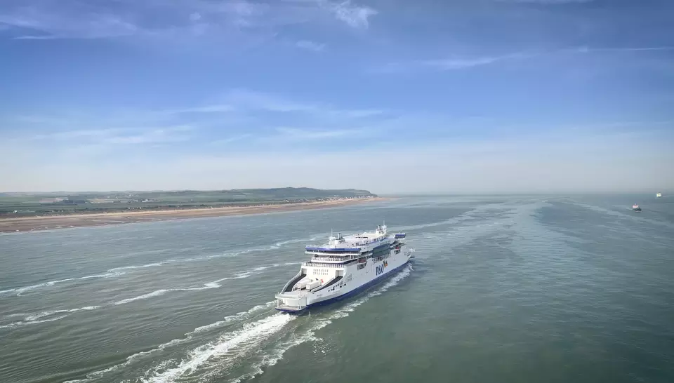 A P&O ferry at sea with the coastline visible on the left.