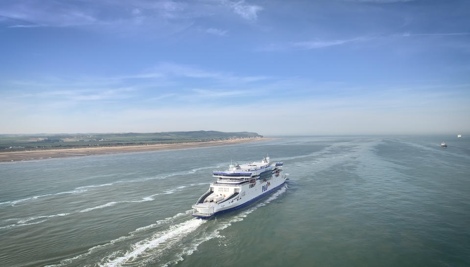 A P&O ferry at sea with the coastline visible on the left.