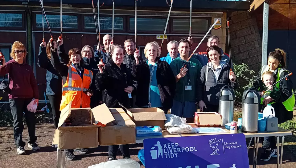 Garston Community Clean Up event with Volunteers holding up litter pickers with Veolia volunteers
