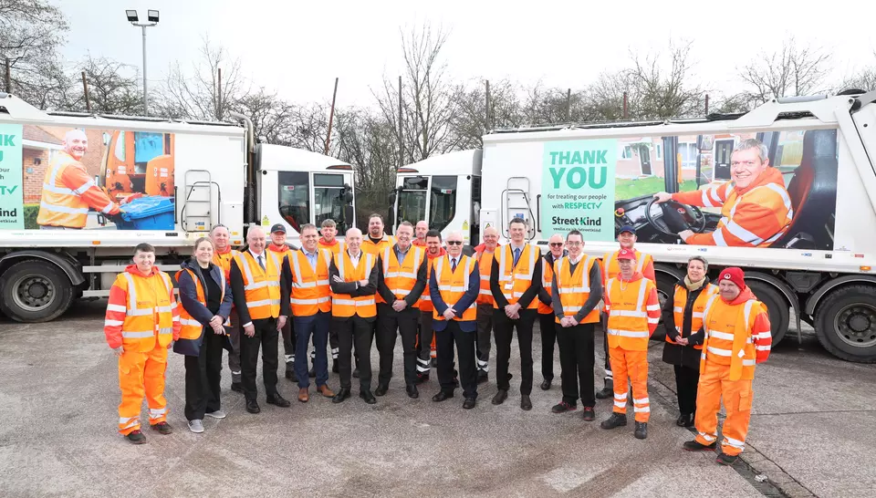 Veolia team members gathered in front of two vehicles at a depot to launch the street kind campaign