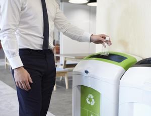 Man placing plastic bottle into recycling bin