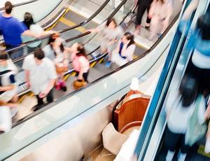 blurred image of lots of people on escalotors  