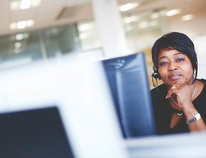 woman smiling behind a computer 
