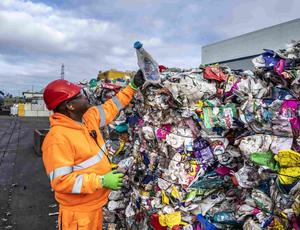 man next to giant pile of rubbish 