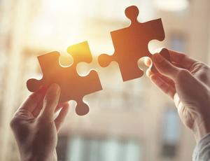 jigsaw pieces being held up together 