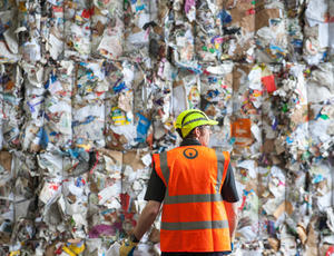 Veolia worker in front of a wall of plastic 