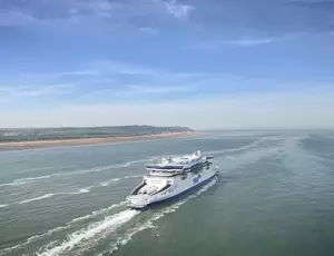 A P&O ferry at sea with the coastline visible on the left.
