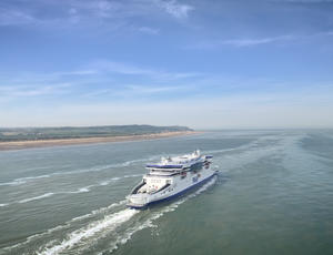 A P&O ferry at sea with the coastline visible on the left.