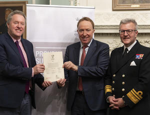 three people holding up a signed document