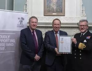 three people holding up a signed document