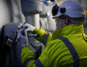 A Veolia operative turns a valve on the boiler.