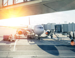 airplane loading in airport at sunset