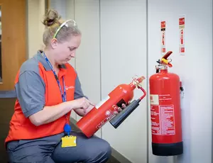 A person checking fire extinguisher 
