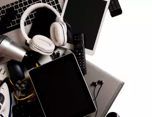A pile of waste electrical and electronic items are stacked up against a white background