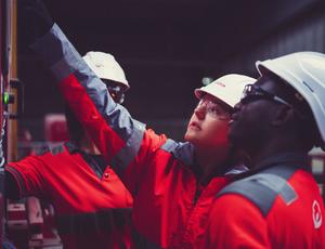 Veolia operatives point at a piece of machinery as they discuss solutions.