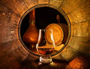 Scotch whiskey glass inside a barrel