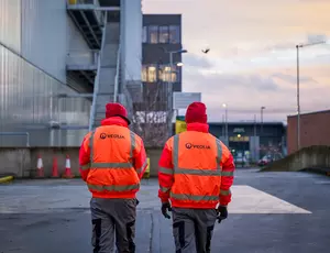 Veolia workers walking towards a facility in hi-vis 
