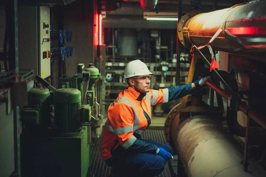 A man from Veolia checking energy pipelines to improve a UK data centre's PUE