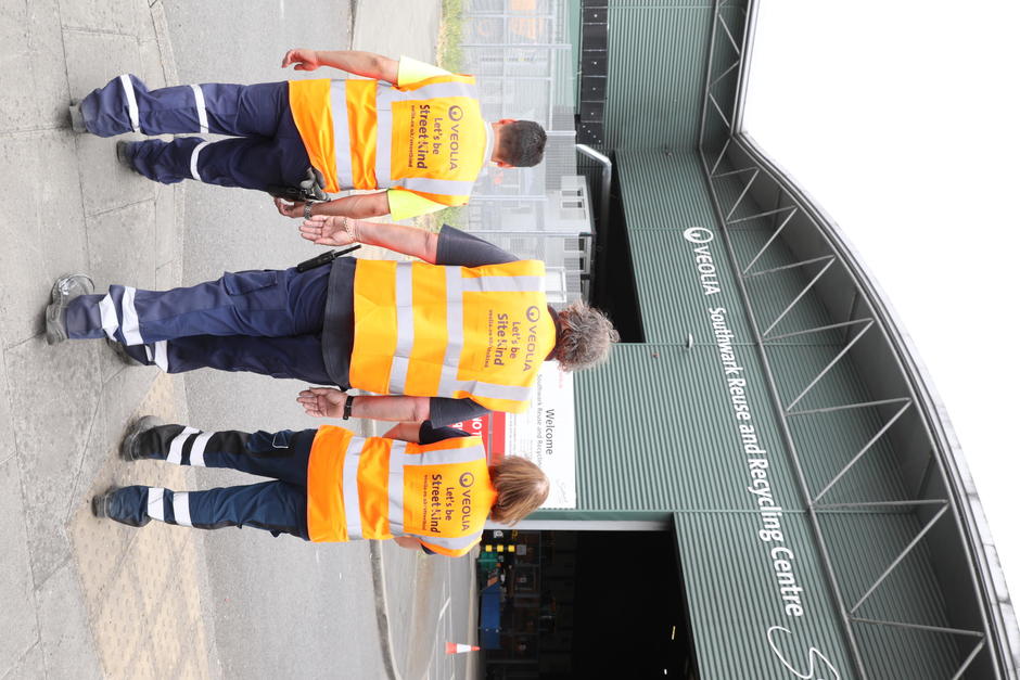 Three frontline operatives walk away from the camera showing their high vis vests with the SiteKind logo