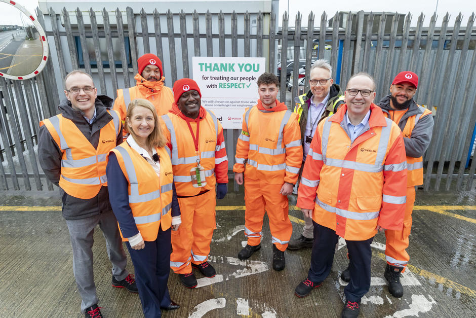 Veolia operatives, Sussex Police and Crime Commissioner and Council members stand smiling at the camera in front of a sign that says 'Thank you for treating our people with respect'.