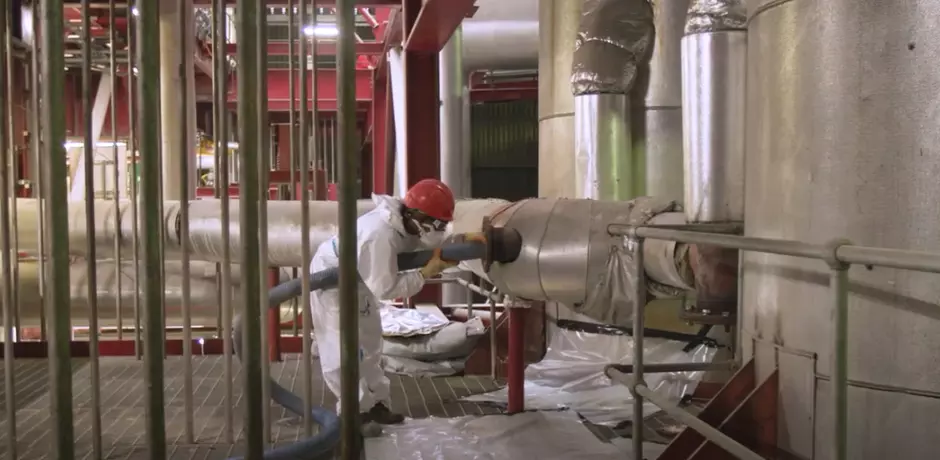 Veolia employee in white workwear and a red hardhat working on ERF services