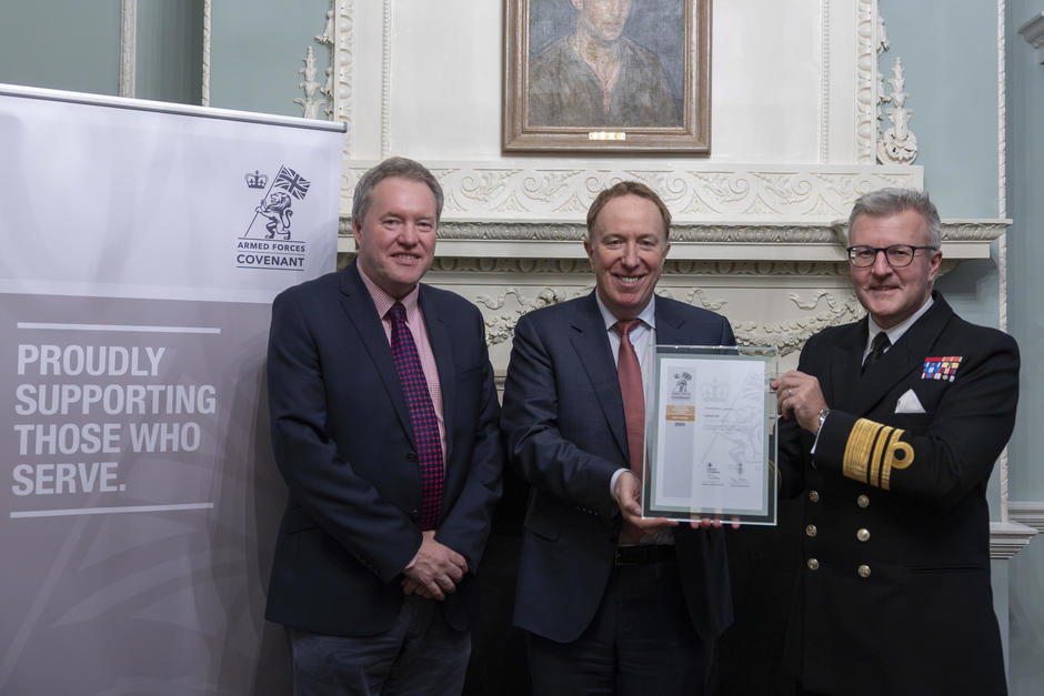 three people holding up a signed document