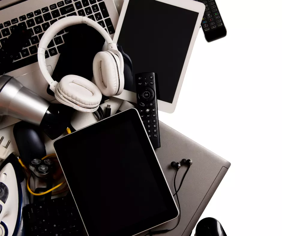 A pile of waste electrical and electronic items are stacked up against a white background
