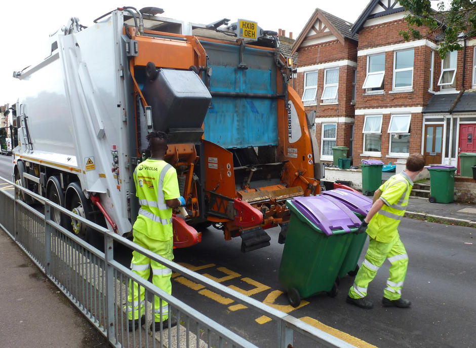 Two Veolia employees placing bins in lorry
