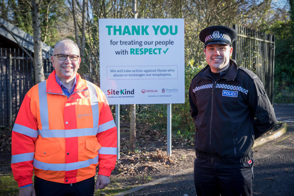 Richard Hulland and a police officer stand next to a SiteKind Welcome sign that thanks visitors for treating Veolia's frontline staff with kindness and respect