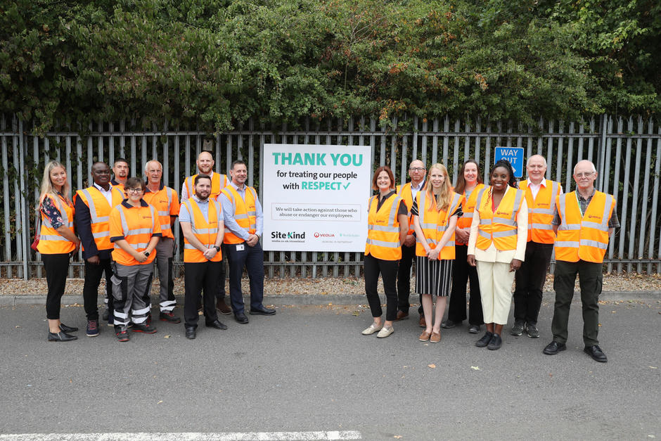Veolia frontline operatives and senior management stand beside the SiteKind sign.