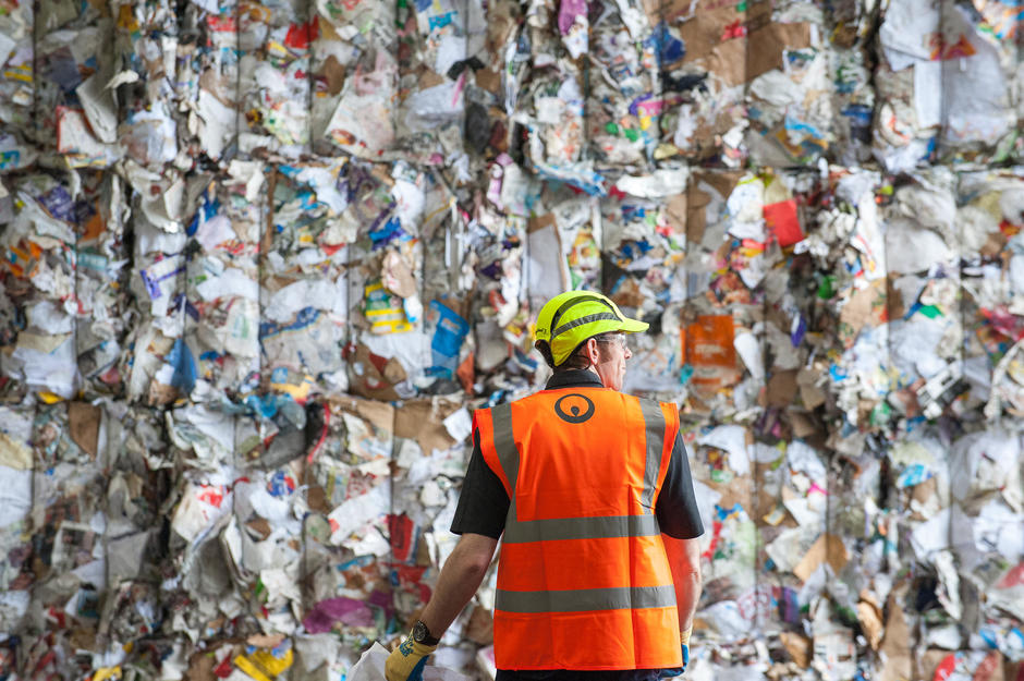 Veolia worker in front of a wall of plastic