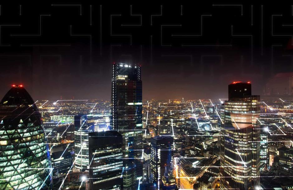The photo shows a city skyline lit up at night.