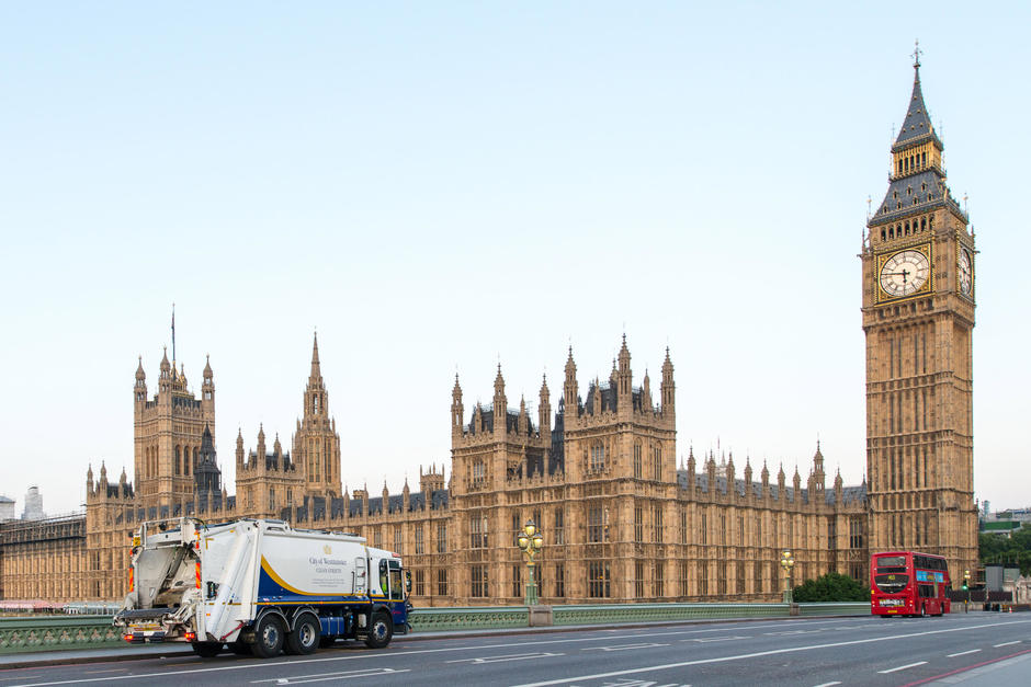 A Veolia Westminster collection vehicle drives over a bridge towards the Houses of Parliament