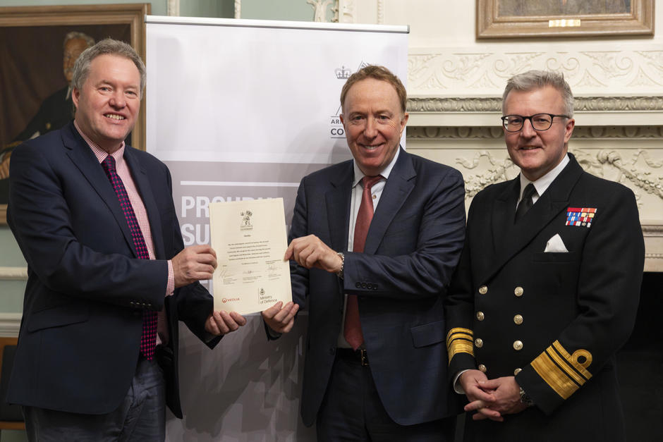 three people holding up a signed document