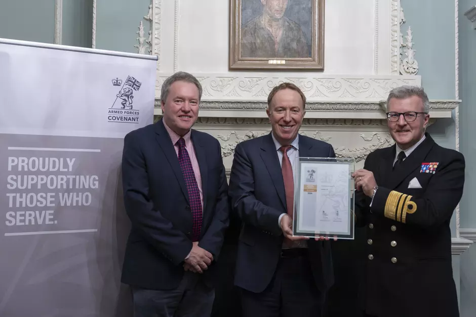 three people holding up a signed document