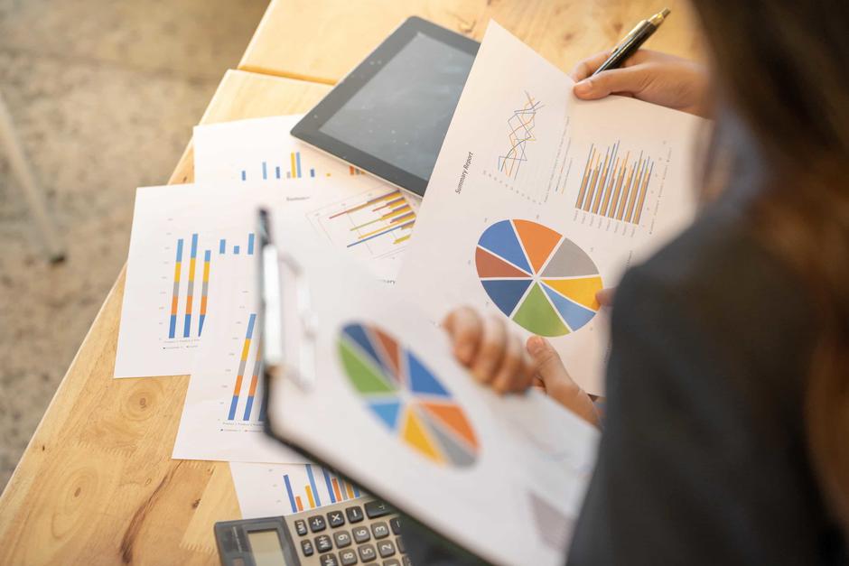 a person at a desk holding graphs and charts data