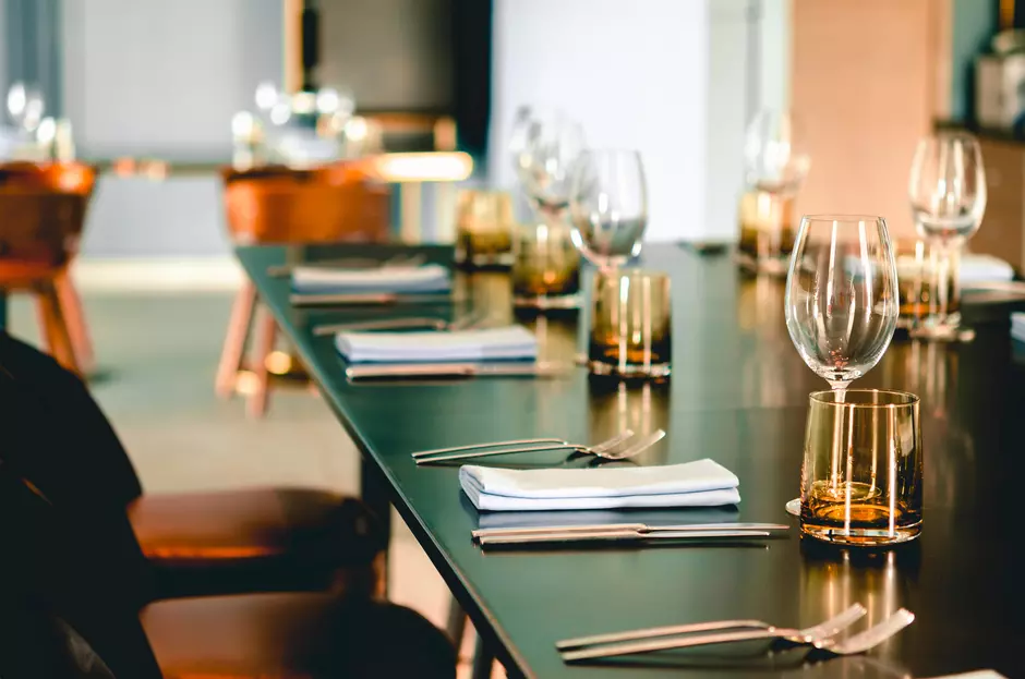 Empty glasses, plate, fork, knife on the table served for dinner in the modern restaurant