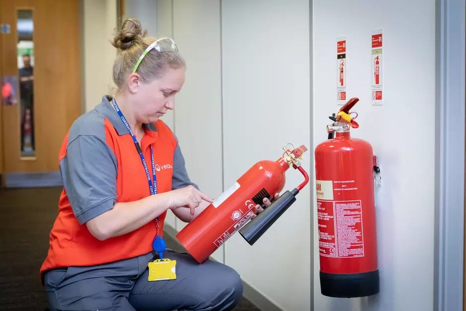 A person checking fire extinguisher 