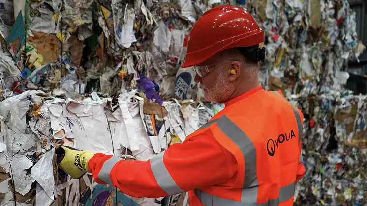 Veolia worker inspecting paper and cardboard waste 