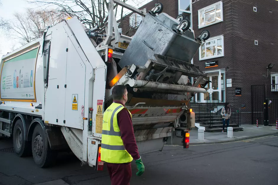 Waste collection lorry by apartment block