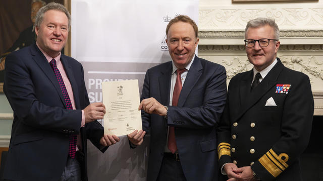 three people holding up a signed document