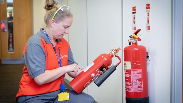 A person checking fire extinguisher 
