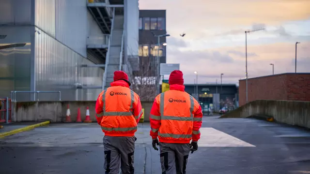 Veolia workers walking towards a facility in hi-vis 