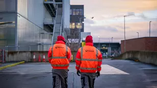 Veolia workers walking towards a facility in hi-vis 